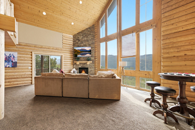 5404 Mountain View Road Coalville, UT 84017 - Photo 7 of 50 Vaulted wood-paneled ceiling, floor-to-ceiling windows, stone fireplace with mantel, and a sliding glass door