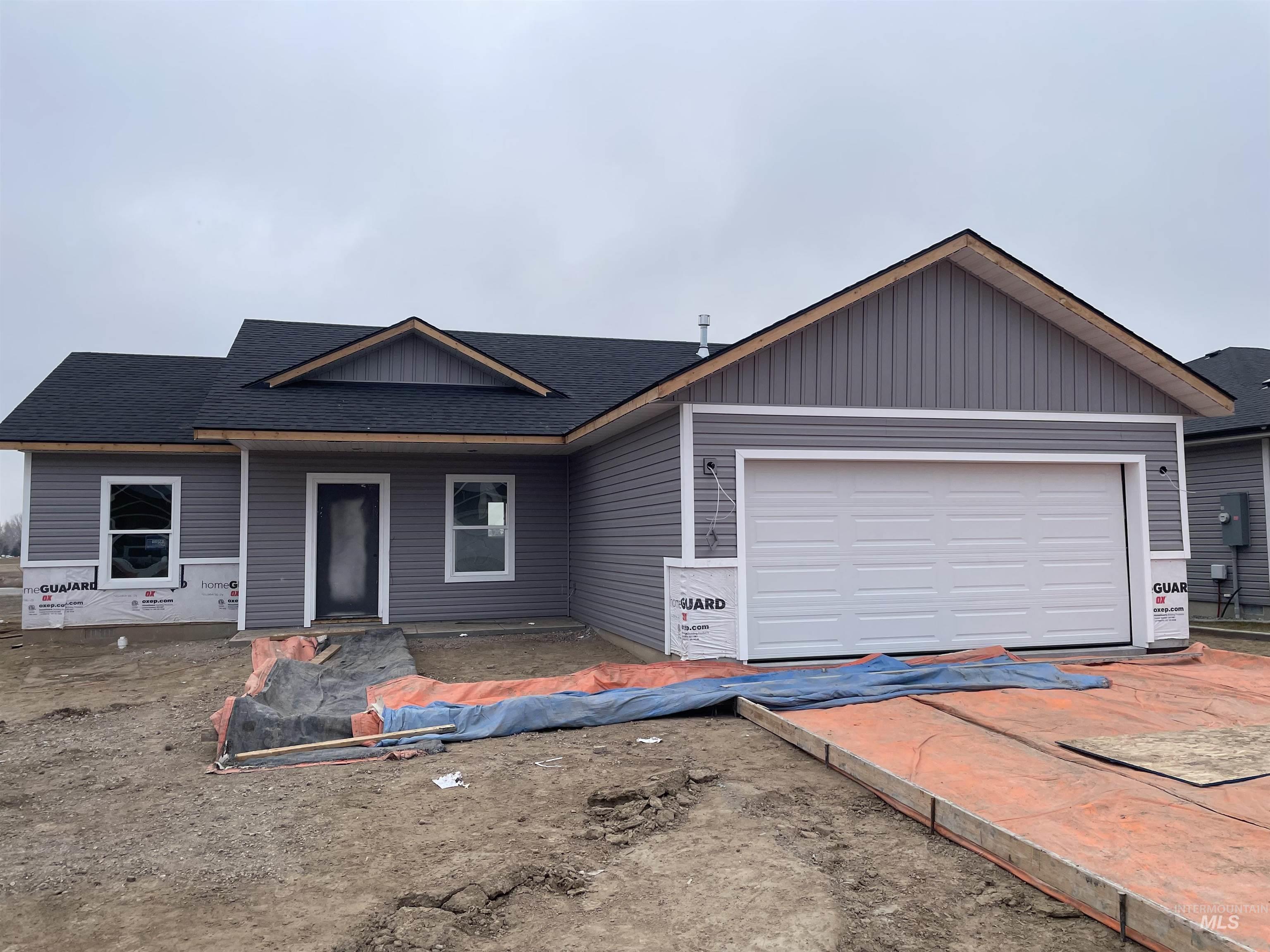 View of front of property with roof with shingles, a garage, and a porch