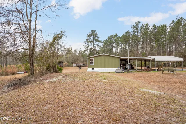 a view of a large building next to a yard with large trees