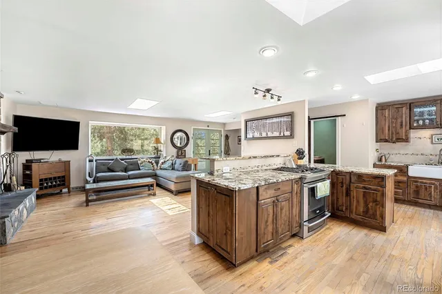 a kitchen with stainless steel appliances granite countertop a sink stove and refrigerator