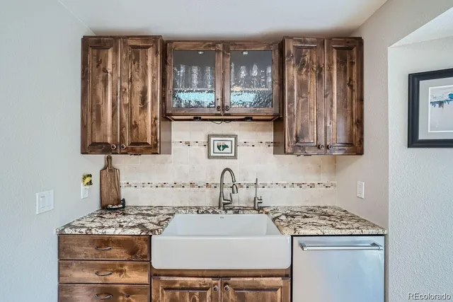 a kitchen with granite countertop stainless steel appliances a refrigerator stove top oven and sink