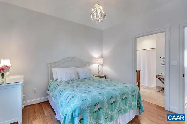 a bedroom with a bed and a chandelier