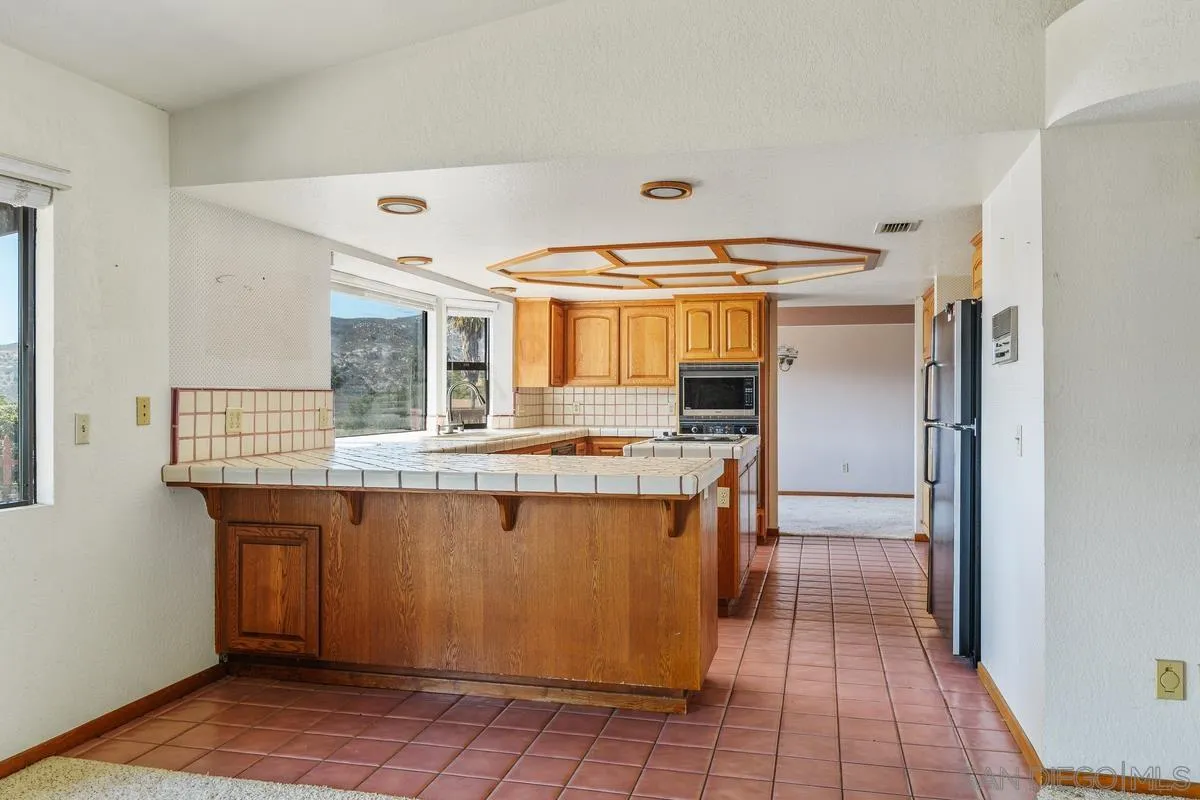 10099 El Capitan Real Road El Cajon, CA 92021 - Photo 15 of 41 a kitchen with stainless steel appliances granite countertop a refrigerator and a sink