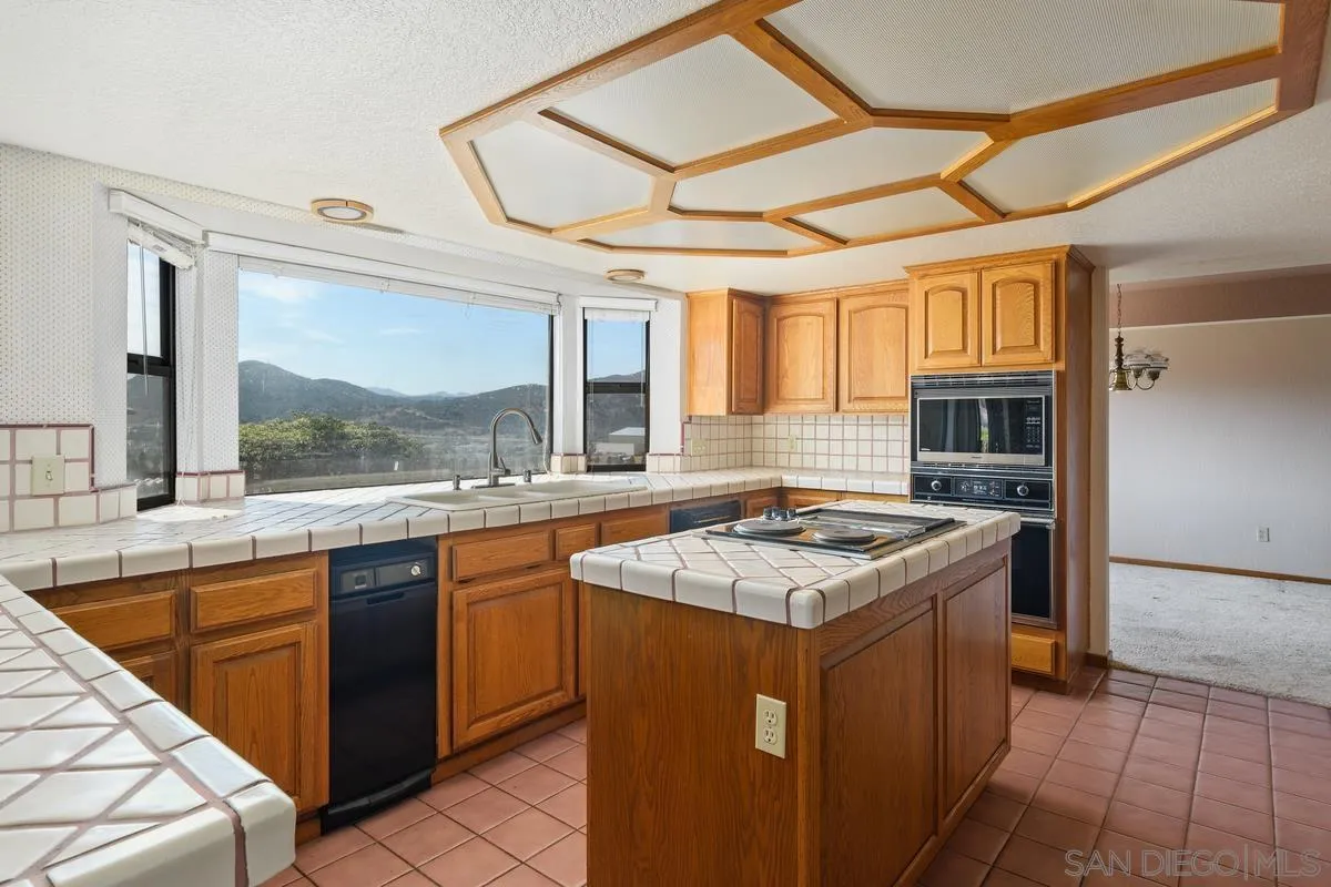 10099 El Capitan Real Road El Cajon, CA 92021 - Photo 16 of 41 a kitchen with a stove top oven sink and large window