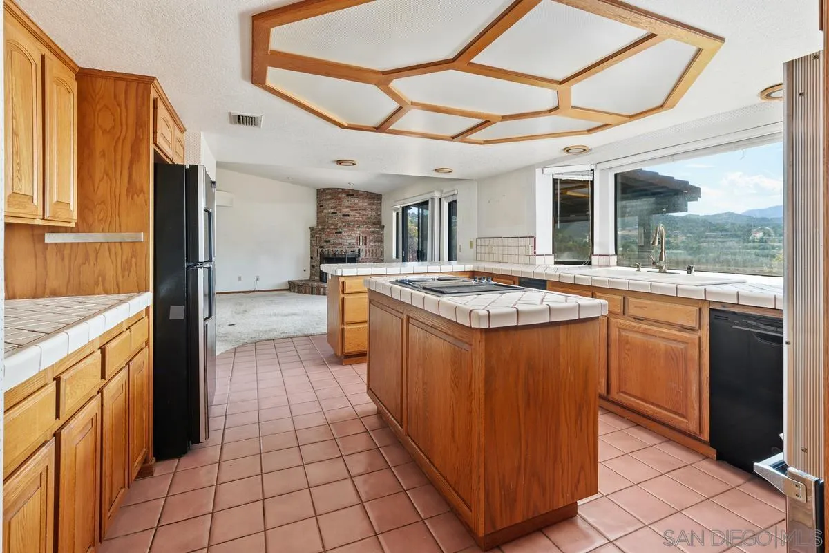 10099 El Capitan Real Road El Cajon, CA 92021 - Photo 17 of 41 a kitchen with stainless steel appliances granite countertop a sink and cabinets
