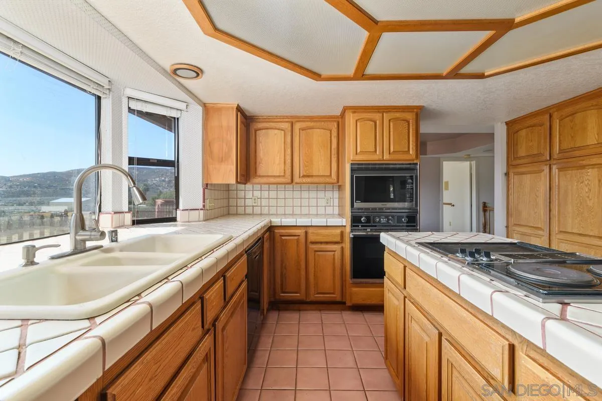 10099 El Capitan Real Road El Cajon, CA 92021 - Photo 18 of 41 a kitchen with granite countertop a sink stove and cabinets