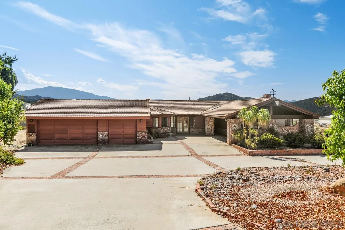 10099 El Capitan Real Road El Cajon, CA 92021 - Photo 3 of 41 a front view of a house with a yard and garage