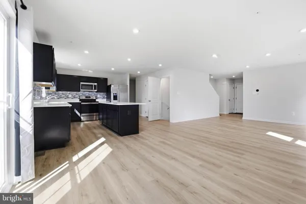 a view of kitchen with kitchen island microwave and cabinets