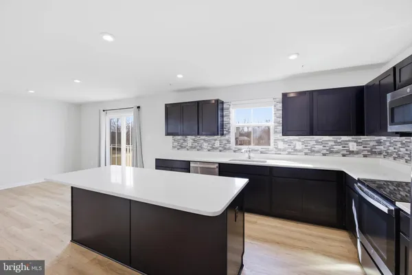 a kitchen with stainless steel appliances granite countertop a sink stove and microwave