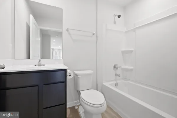 a bathroom with a sink toilet vanity and bathtub