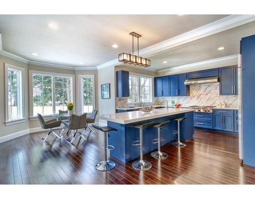 a living room with granite countertop furniture a wooden floor kitchen view and a chandelier