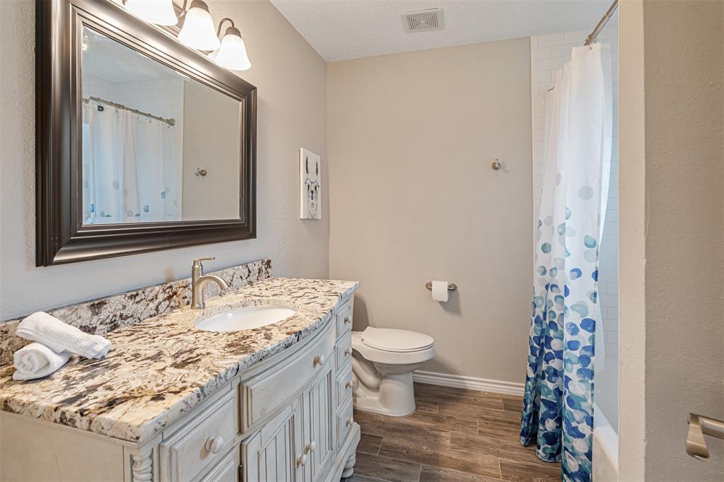 1102 Mill Run Road Athens, TX 75751 - Photo 21 of 35 a bathroom with a granite countertop sink a mirror and a toilet