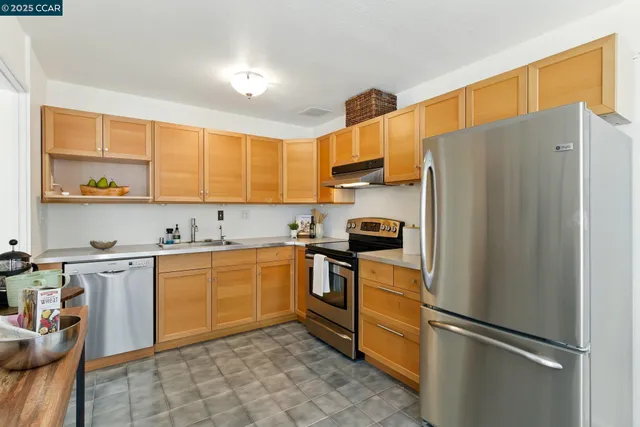 a kitchen with stainless steel appliances cabinets and a table