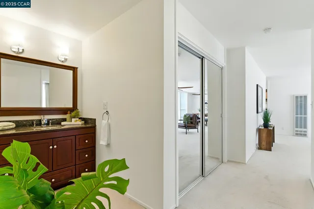 a bathroom with a granite countertop sink toilet a large mirror a shower and a mirror