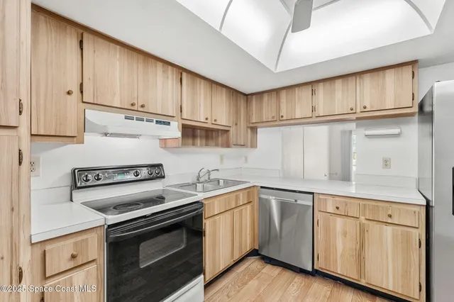a kitchen with stainless steel appliances granite countertop a stove a sink and a refrigerator