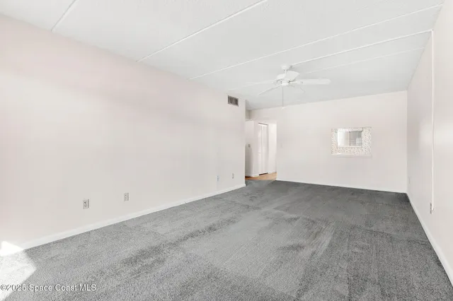 a view of a hallway with wooden floor and a bathroom