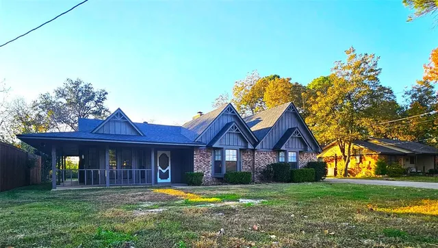 a front view of a house with a garden and trees