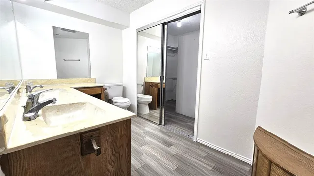 a kitchen with a sink a stove and wooden floor