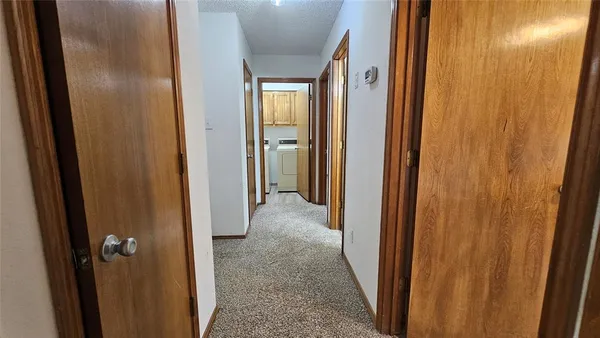 an empty room with wooden floor chandelier and windows