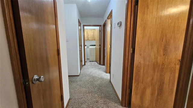 an empty room with wooden floor chandelier and windows