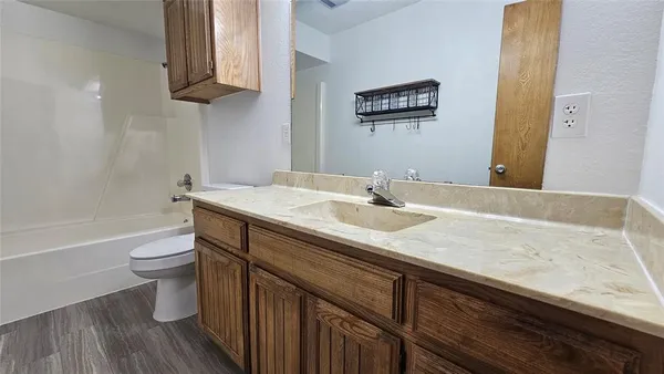 a white toilet sitting next to a bath tub