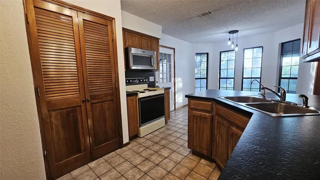 a kitchen with stainless steel appliances granite countertop a sink and a stove