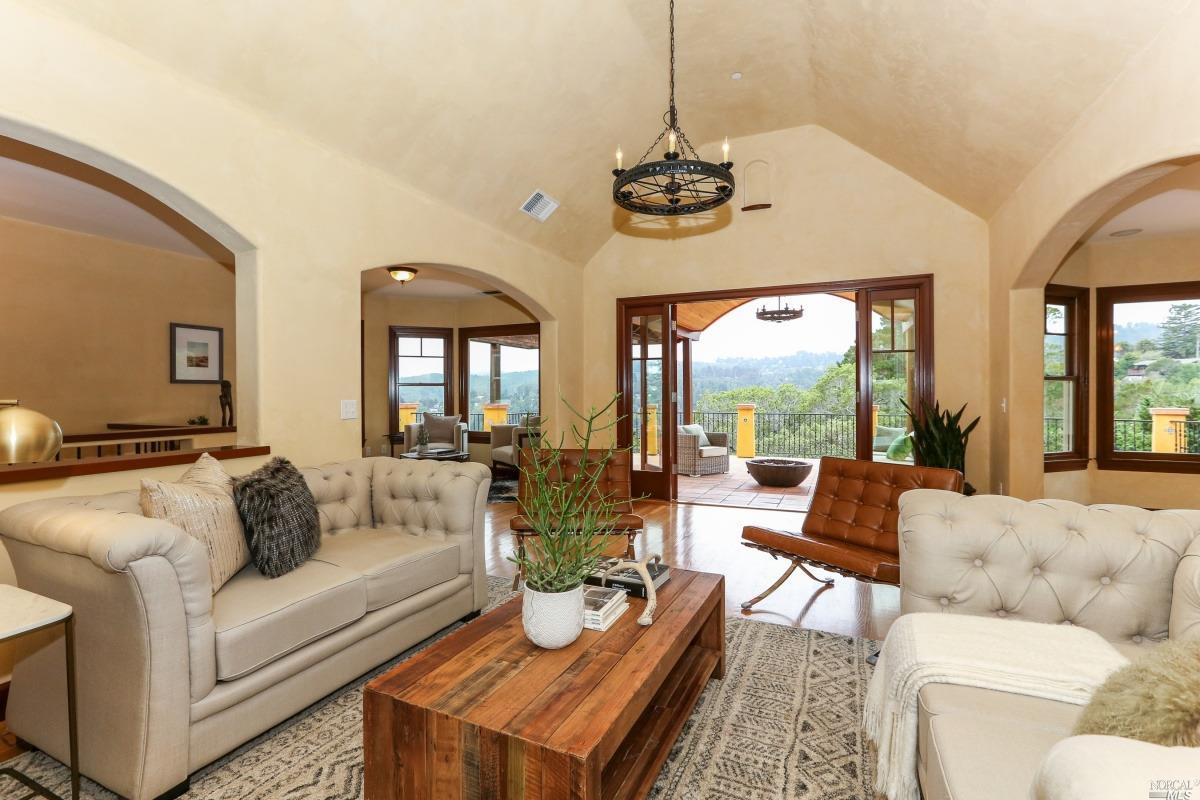 a living room with furniture chandelier and a large window