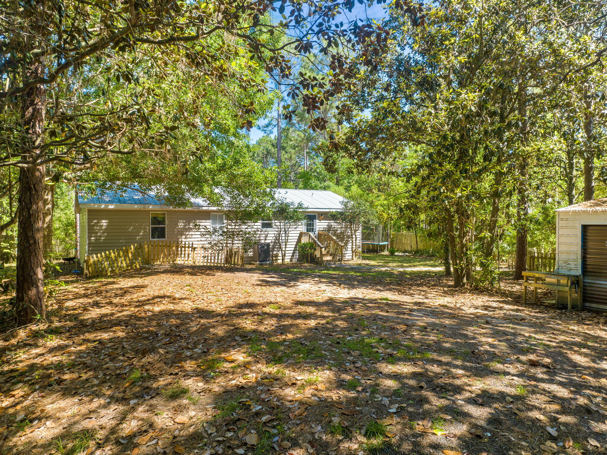 232 Churchill Bayou Road Santa Rosa Beach, FL 32459 - Photo 27 of 32 a backyard of a house with table and chairs