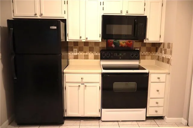 a kitchen with a refrigerator and a stove