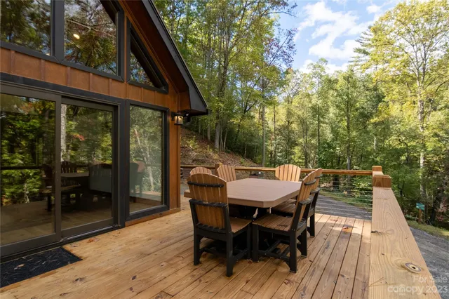 a view of a patio with table and chairs with wooden floor and fence