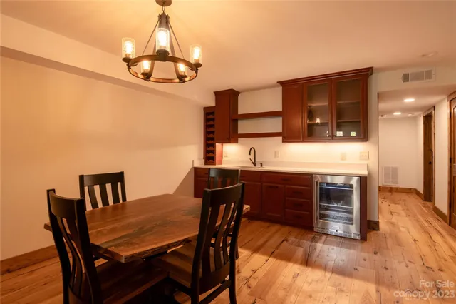 a dining room with furniture a chandelier and wooden floor