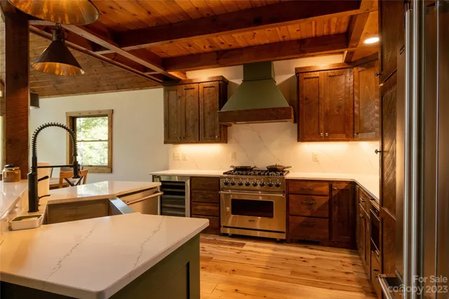 a kitchen with stainless steel appliances granite countertop a stove a sink and a microwave