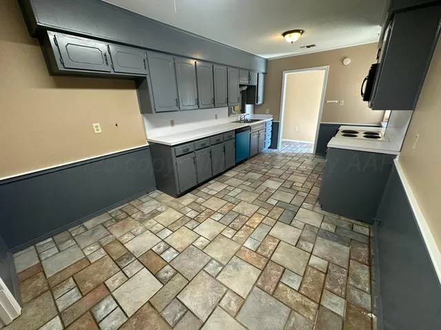 a kitchen with a sink refrigerator and microwave