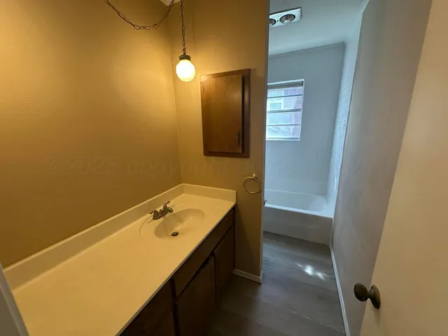 a bathroom with a tub sink and mirror