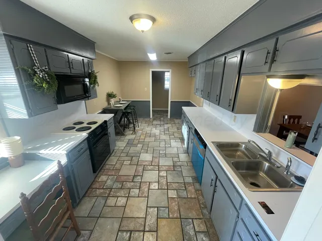 a kitchen with stainless steel appliances granite countertop a sink and a stove