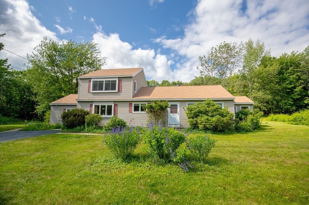 89 Whitney Road Ashby, MA 01431 - Photo 2 of 30 a front view of a house with a yard and potted plants