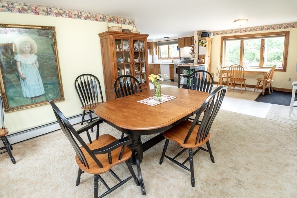 89 Whitney Road Ashby, MA 01431 - Photo 5 of 30 a view of a dining room and livingroom with furniture wooden floor and a rug