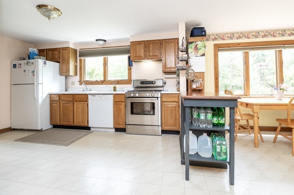 89 Whitney Road Ashby, MA 01431 - Photo 7 of 30 a kitchen with a stove a refrigerator and wooden cabinets