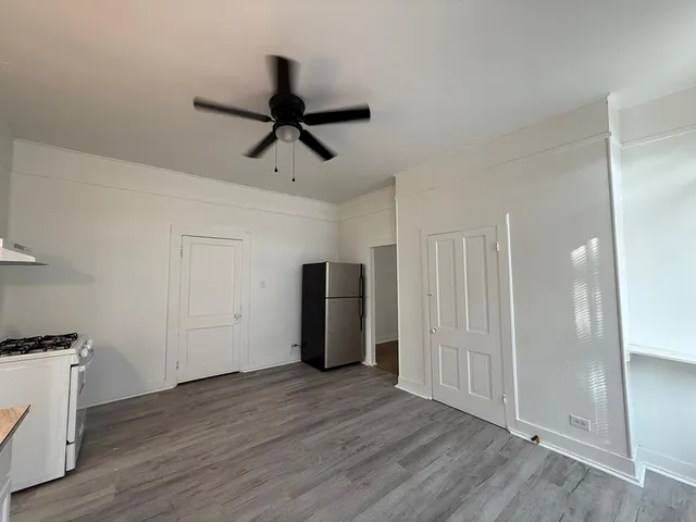 a view of empty room with wooden floor