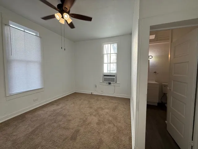 a view of a room with a ceiling fan and bathroom