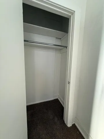 a view of empty room with a refrigerator and microwave