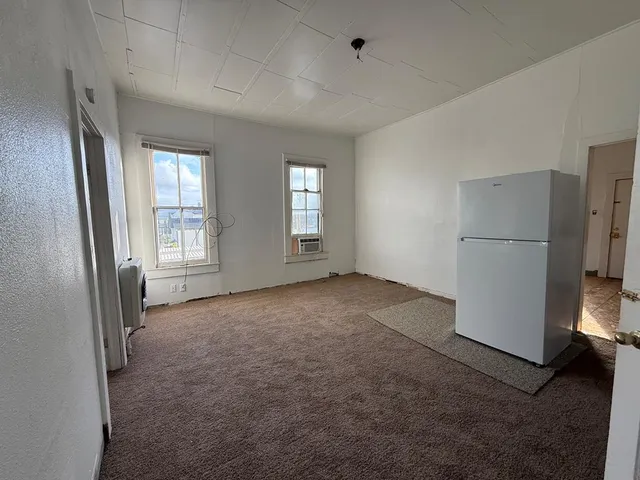 an empty room with windows and closet