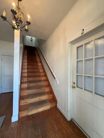 a view of a hallway with wooden floor and staircase