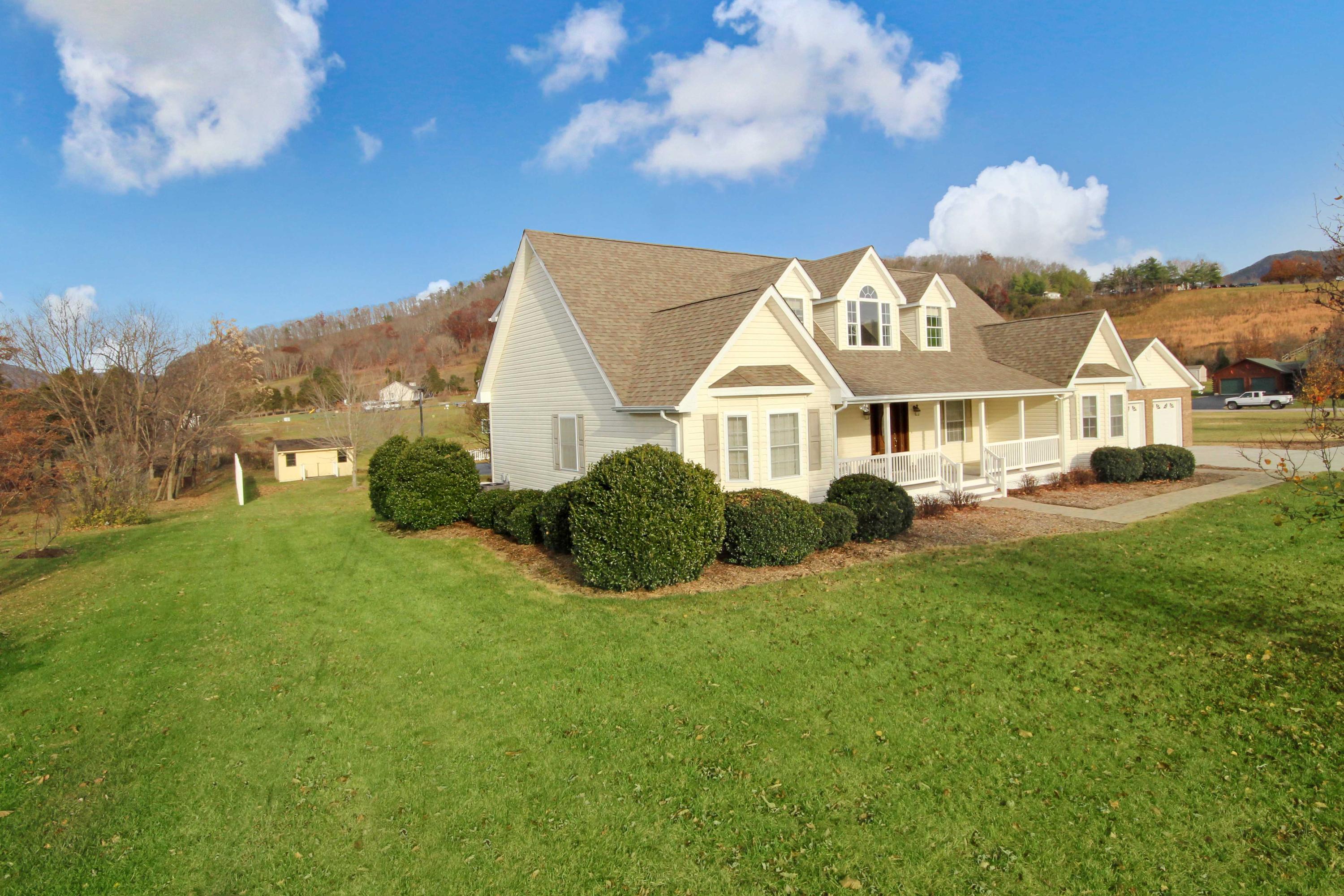 4690 Crosier Road Elliston, VA 24087 - Photo 7 of 79 a view of a white house with a big yard and large trees
