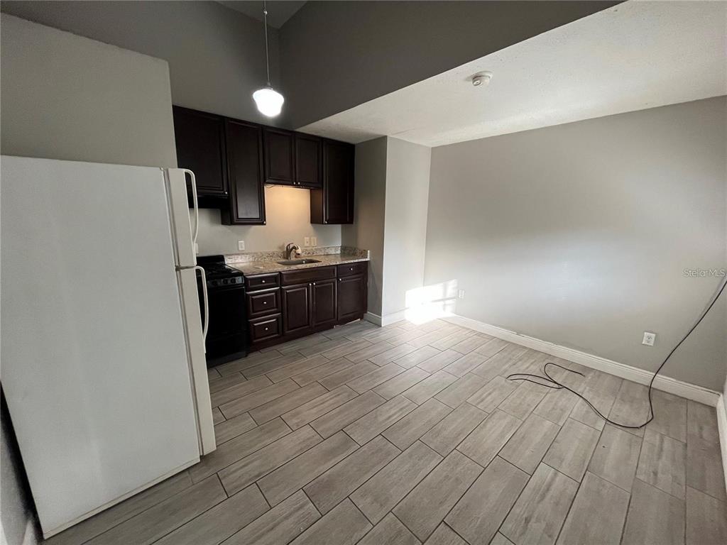 2795 L B McLeod Road, Unit C Orlando, FL 32805 - Photo 4 of 5 a view of a kitchen with a sink and a refrigerator