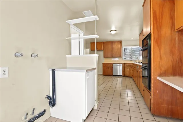 a kitchen with a sink a refrigerator and cabinets