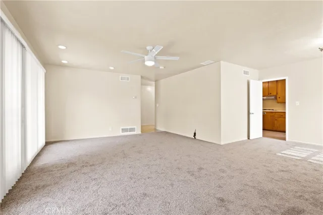 an empty room with closet and a ceiling fan