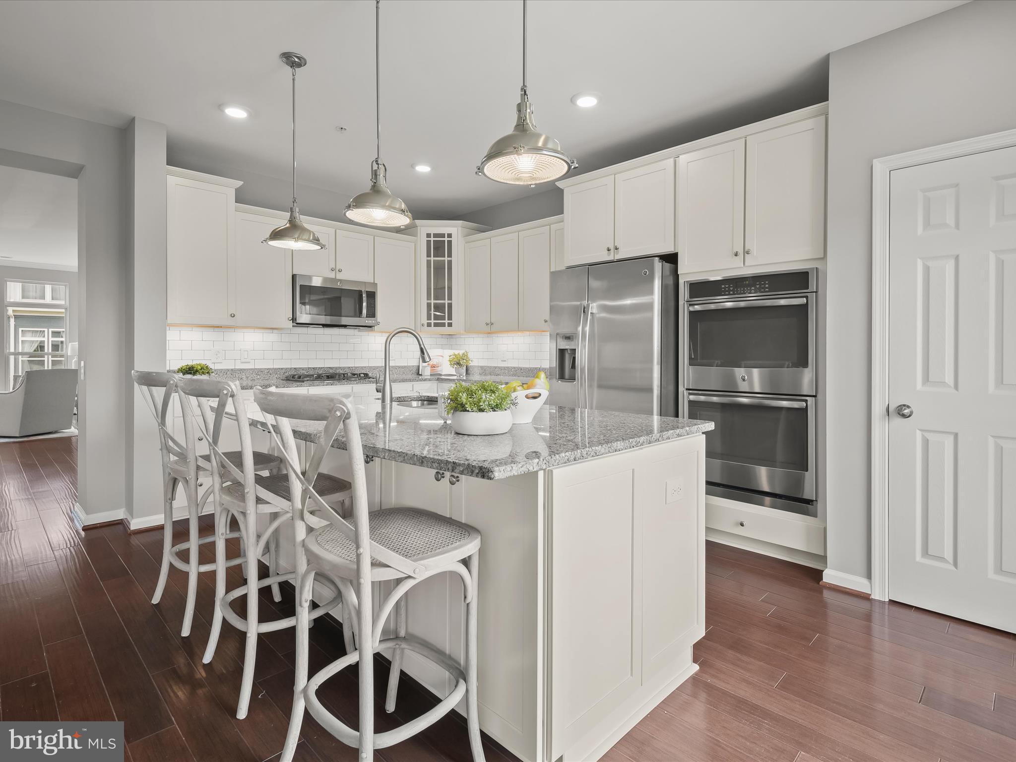 179 Copley Circle, Unit 30B Gaithersburg, MD 20878 - Photo 13 of 41 a kitchen with kitchen island granite countertop a refrigerator and microwave