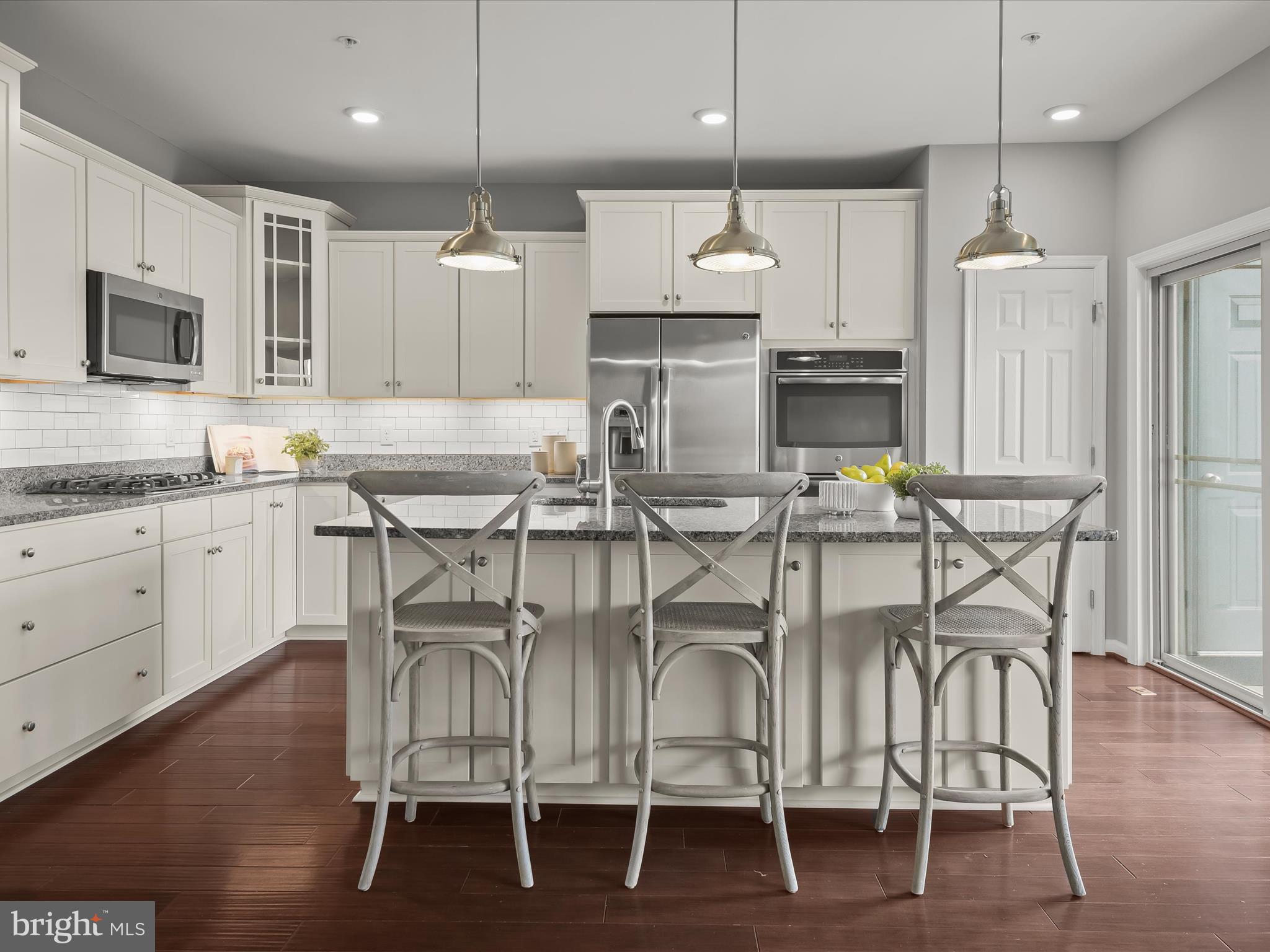179 Copley Circle, Unit 30B Gaithersburg, MD 20878 - Photo 14 of 41 a kitchen with granite countertop stainless steel appliances a dining table chairs sink and microwave