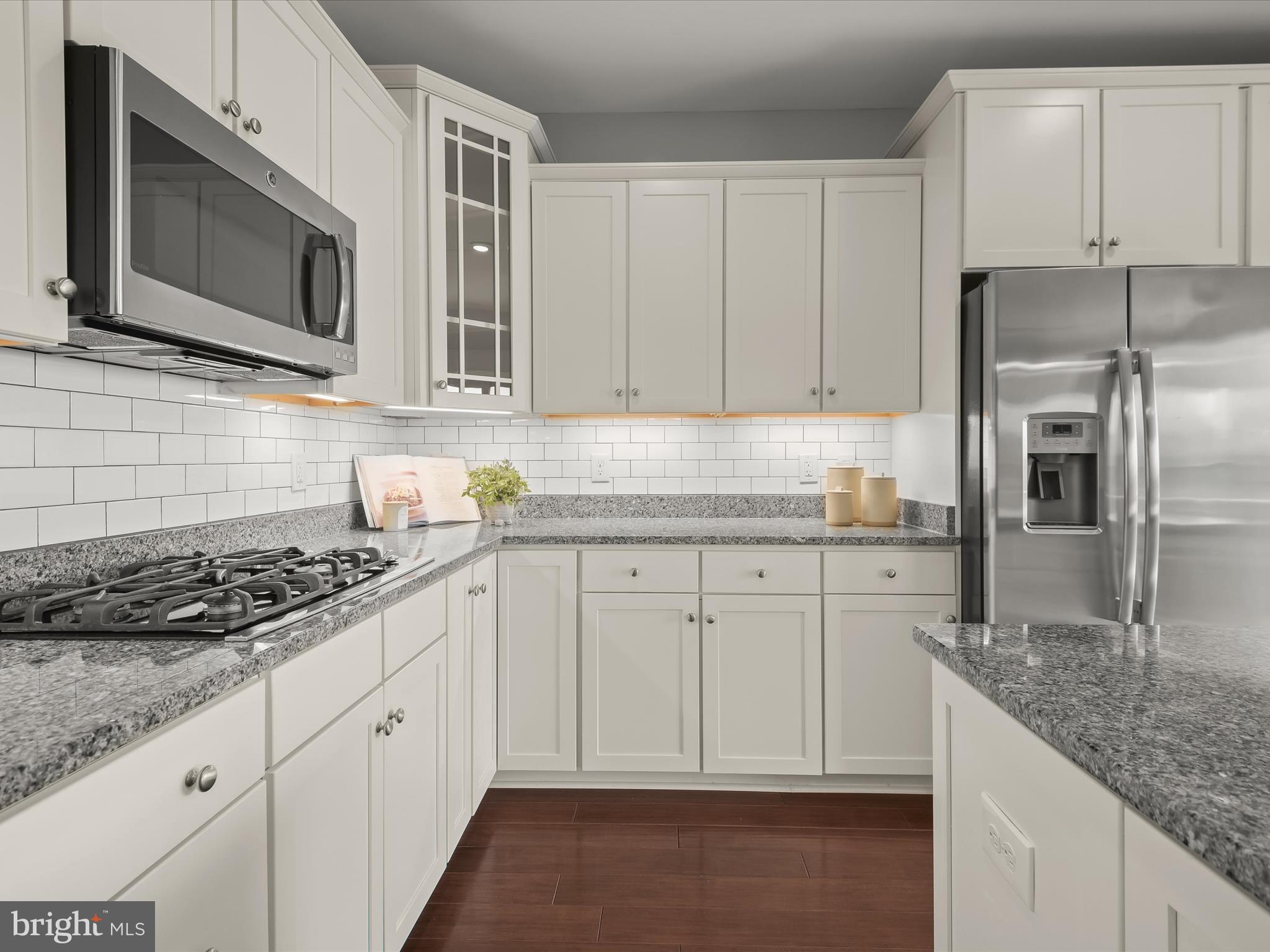 179 Copley Circle, Unit 30B Gaithersburg, MD 20878 - Photo 16 of 41 a kitchen with granite countertop white cabinets stainless steel appliances and a sink